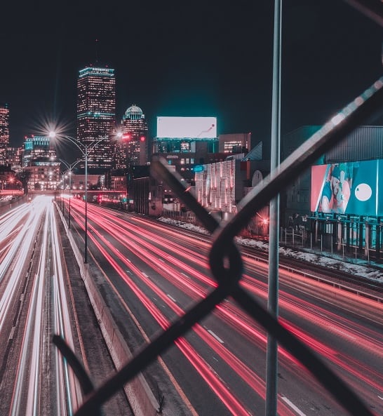 the city at night with traffic on the tracks