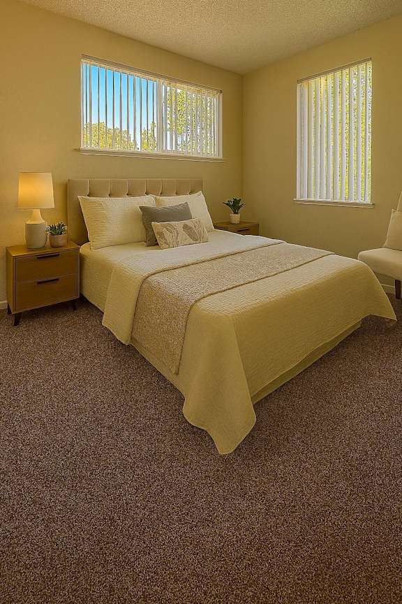 A bedroom with a bed, nightstand, and chair.