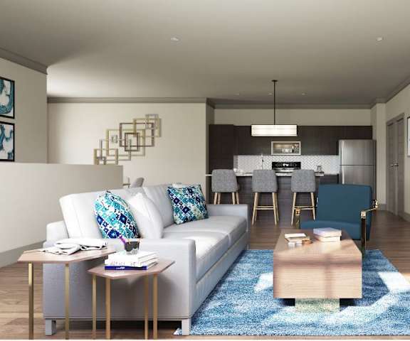 A living room and kitchen with a couch and a table and kitchen in the background at 49 West. 