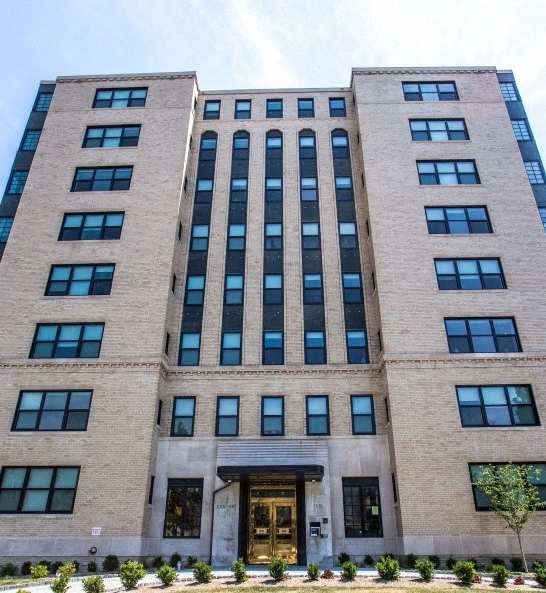 A tall building with a mix of beige and blue glass windows.