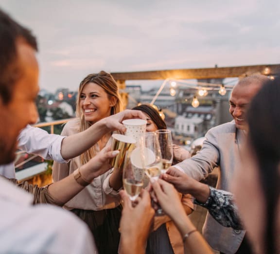 a group of people toasting champagne on a rooftop