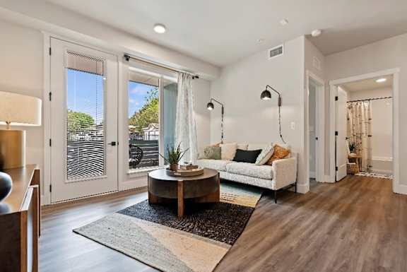 A modern living room with a wooden floor and a large window.