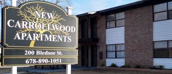 a sign in front of a building that says new carrollwood apartments