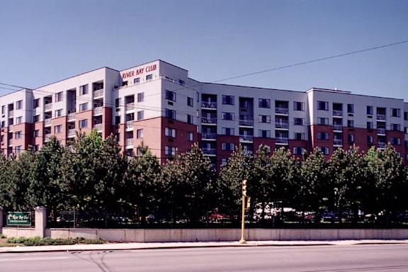 A large multi-story building with the words "River Bay Club" on the side.