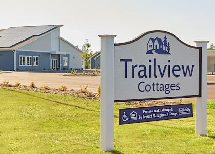A sign for Trailview Cottages in front of a building.