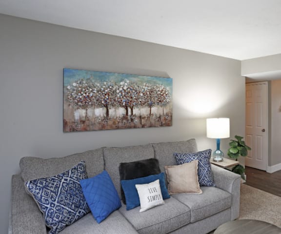 A grey couch with blue and white pillows in a living room.