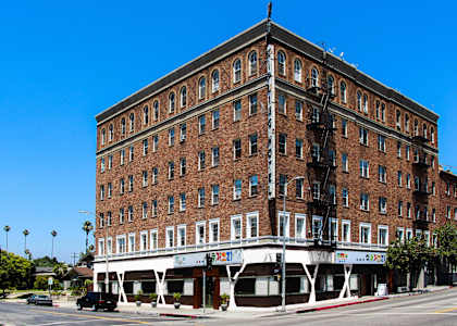 A large red brick building with a white awning on the bottom.