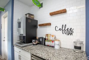 A coffee bar with a black fridge and a white counter. at The Preserve at Pine Valley Apartments, Wilmington