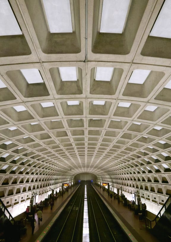 a subway tunnel with a ceiling and train tracks