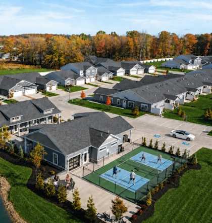 A bird's eye view of a neighborhood with houses and a tennis court.