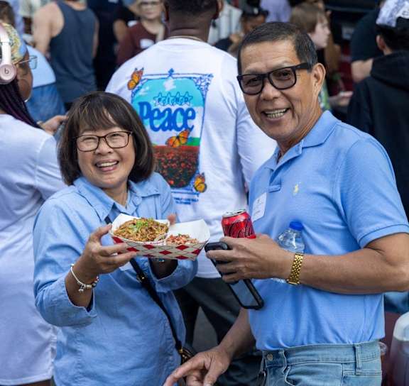 a man and a woman holding a plate of food