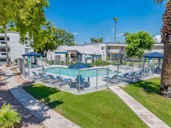a resort style pool with lounge chairs and umbrellas  at Sofia Apartments, Tempe, AZ, 85283