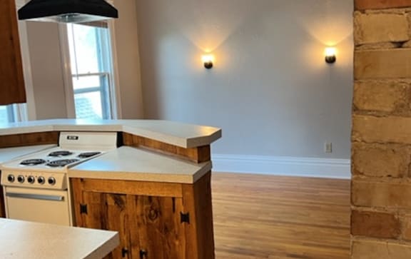 a kitchen with a stove top oven next to a brick wall