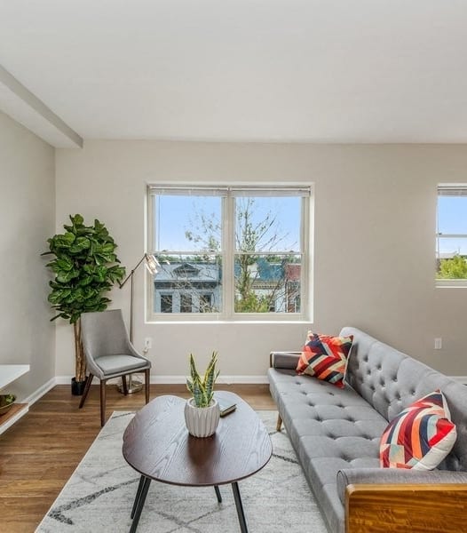 a living room with a couch and a coffee table in front of a window