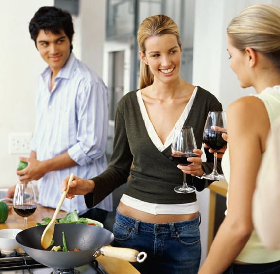 a group of people in a kitchen preparing food and drinking wine at Villas At Crystal Lake, Swansea