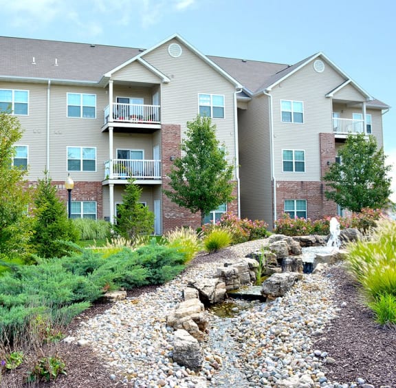 a yard with a waterfall in front of an apartment building at Villas At Crystal Lake, Swansea, IL, 62226