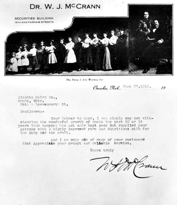 A black and white photo of a group of people with a letter below it.