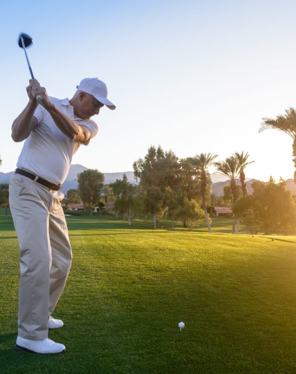 a man swinging a golf club at a golf ball