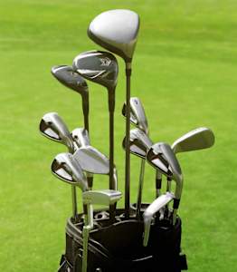 A set of golf clubs in a holder on a golf course.