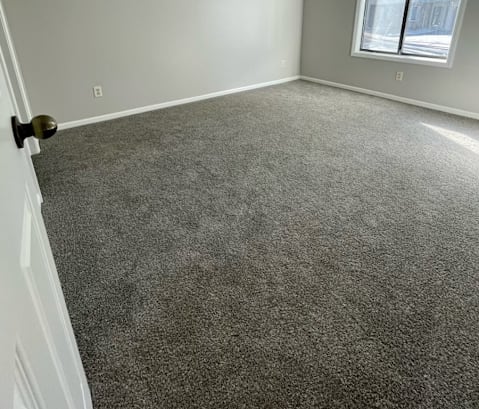 an empty room with a window and a door
