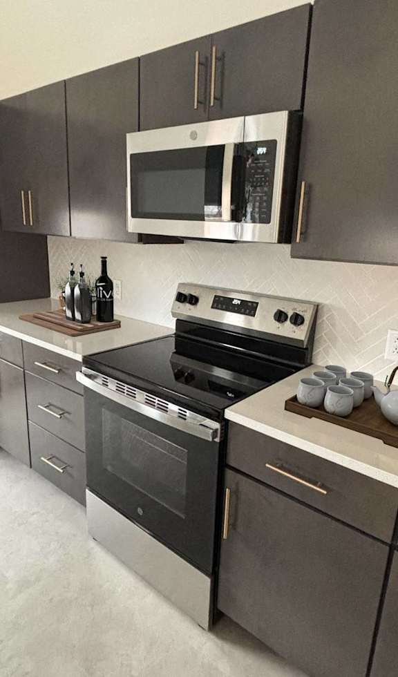 A kitchen with a white counter and black stools.