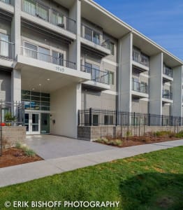 an exterior view of an apartment building with a sidewalk and grass