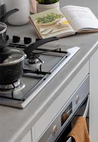 a modern kitchen with grey cabinets and black appliances