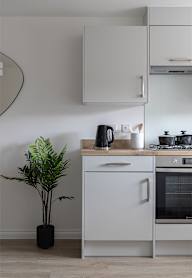 a modern kitchen with grey cabinets and black appliances