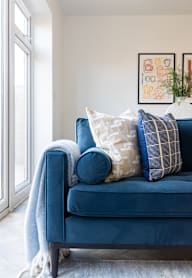 a bedroom with a bed and a nightstand with a lamp and a framed picture