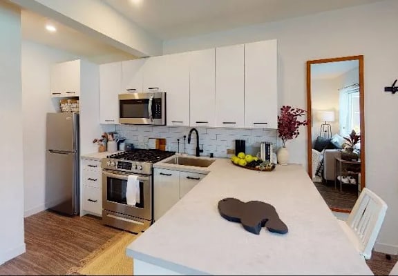 A kitchen with white cabinets and a white island with a heart-shaped object on it.