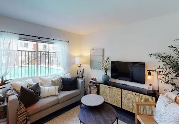 A living room with a couch, a chair, a table, and a television.