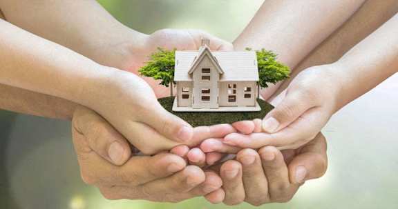 hands holding a model of a house