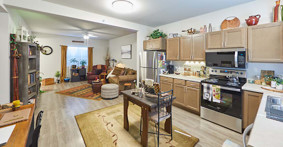 A kitchen with a refrigerator, oven, and microwave.