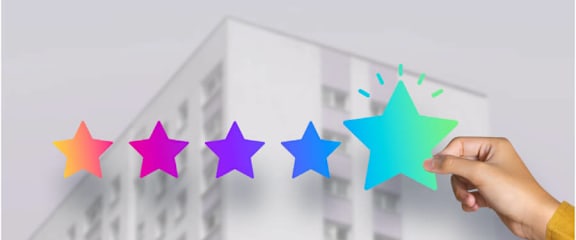 A hand is holding a green star that is the last in a series of five stars of different colors.