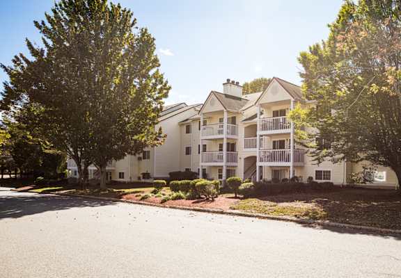 Apartment building with a tree in front of it.