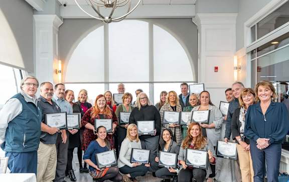 A group of people holding certificates in a room.