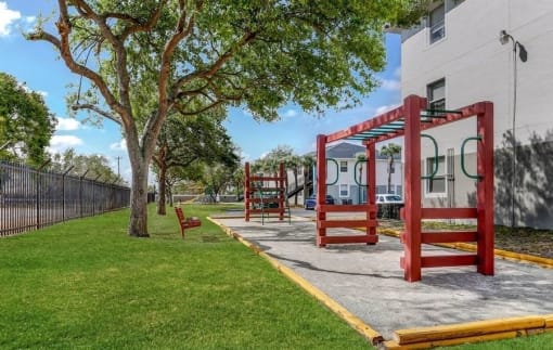 Playground in courtyard with trees and grass