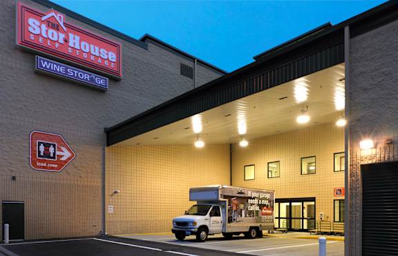 A truck is parked in front of a building with a sign that says "Stor House Wine Storage".