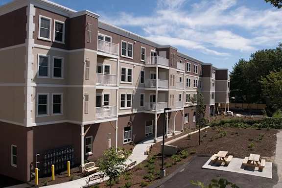 Apartment complex with a courtyard and a small garden.