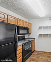 A kitchen with black appliances and wooden cabinets.
