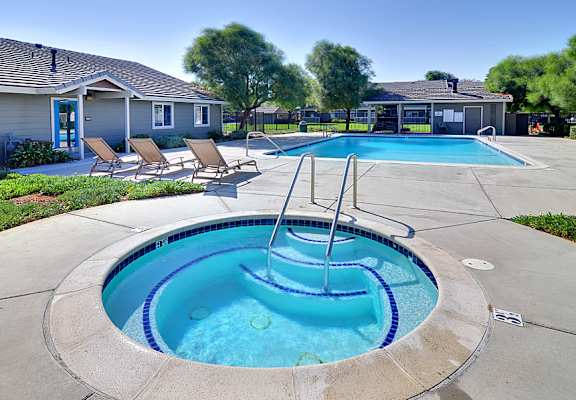 A small pool with a fountain in the middle of it.