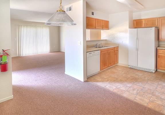 A kitchen with white appliances and wooden cabinets.