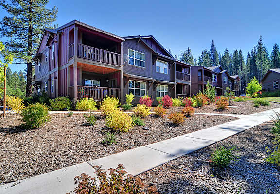 an apartment building with a sidewalk in front of it