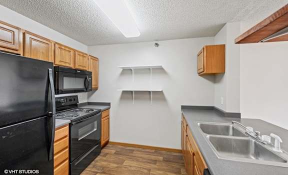 a kitchen with wood cabinets and black appliances