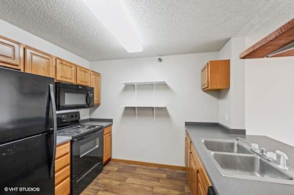 A kitchen with black appliances and wooden cabinets.
