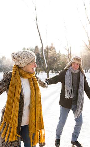 Two people are walking in the snow.