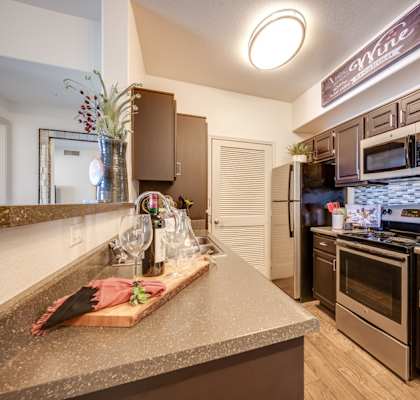A kitchen with brown cabinets and a granite countertop.