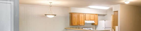 Open Floor Plan with Carpeted Dining and Living Room and Kitchen with Breakfast Bar Blonde Cabinets and White Appliances