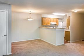Open Floor Plan with Carpeted Dining and Living Room and Kitchen with Breakfast Bar Blonde Cabinets and White Appliances