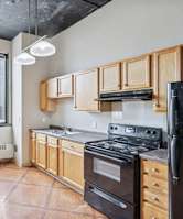A kitchen with black appliances and wooden cabinets.